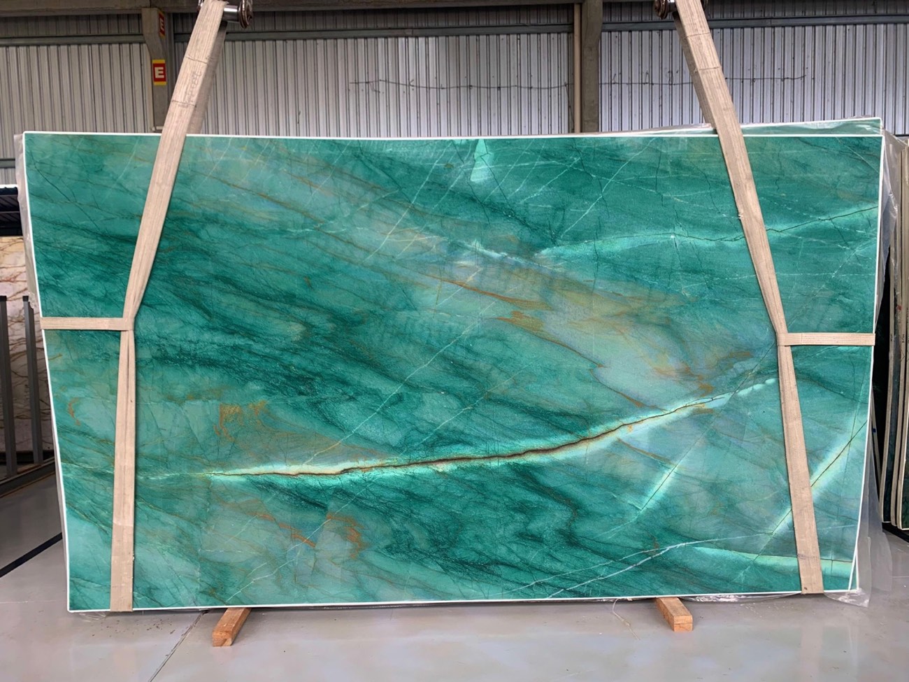 Chapa de quartzito verde intenso com veios brancos em exposição